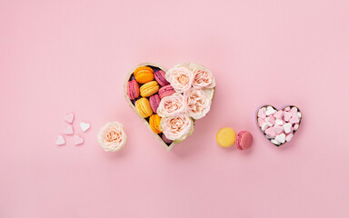 Cookies Macaroons in Gift Box, Rose Flowers and Candies on Pink Background. Holiday Presents Concept