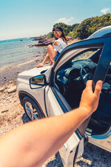 first person point of view man closing door of the car woman sitting on the hood