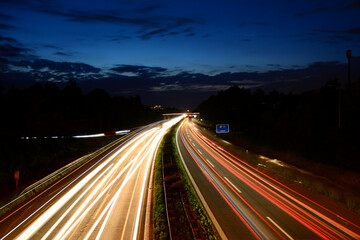 Headlights of cars on a long exposure on the highway at night. Abstract city background