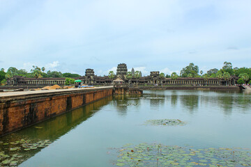 Fototapeta premium SIEM REAP, CAMBODIA. August 7th, 2019: Stone Bridge At Large Towers At Angkor Wat Temple Complex. Angkor Wat Is A Temple Complex In Cambodia And Is The Largest Religious Monument In The World.