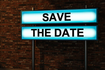Obraz premium Save the date. Black letters on a light box illuminated in front of a red brick wall. Scheduling, appointment, reminder, message, dating, information, countdown and public event. 3D illustration