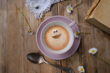 cup with drink coffee cappuccino and foam in smile form on old vintage wooden table, caffeine improves functioning of human brain, stimulates nervous system, health benefits and harms, copy space