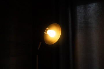Fototapeta na wymiar Black minimalist lamp in modern loft-style cafe or home. Cool interior design idea.