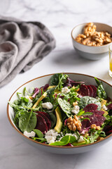 Healthy Salad made from Green Salad Leaves, Rocket Salad, Slices of Beetroot, Avocado, pieces of Feta Cheese, Walnuts and Sesame Seeds.