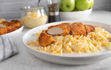 Breaded chicken breast with coleslaw on a plate