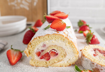 Cake roll with strawberries and whipped cream 