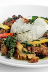 .Pad Krapow Gai spicy Thai Chicken Vegetable Stir Fry on white plate