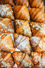 Sprinkle the finished croissants on a baking sheet with almond flakes and powdered sugar