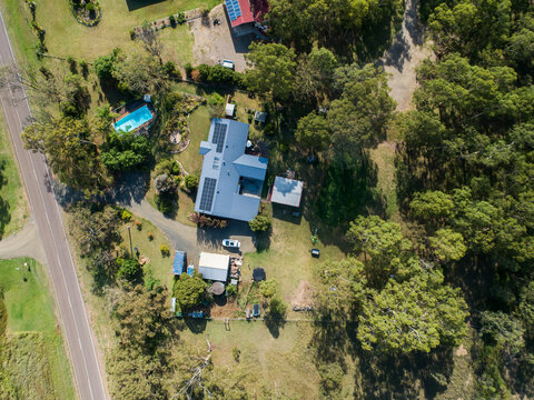 Aerial top down view of rural property with house with solar panels on roof