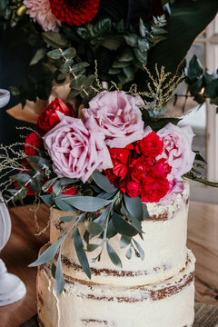 Rustic wedding cake with fresh flower topper.