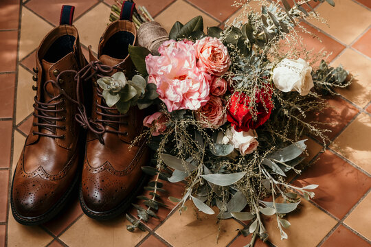 Wedding shoes and flowers on the floor.