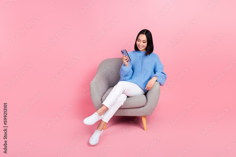 Poster full body photo of charming nice lady sit chair use smart phone isolated on pink color background