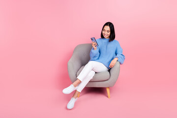 Full body photo of charming nice lady sit chair use smart phone isolated on pink color background