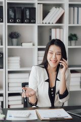 Cheerful business lady working on laptop in office, Asian happy beautiful businesswoman in formal suit work in workplace. Attractive female employee office worker smile.