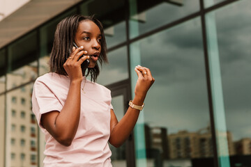 African american woman hold hand phone surfing internet chatting friends colleague call order taxi...