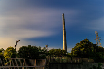 夕日の当たる工業地帯の煙突