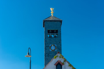 Historischer Feuerwehrturm mit goldenem Engel am Dorfplatz in Donsieders. Region Pfalz im...