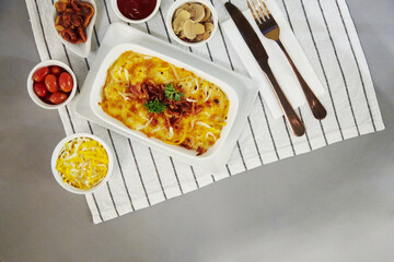 Top view lasagna and ingredients on fabric flat lay