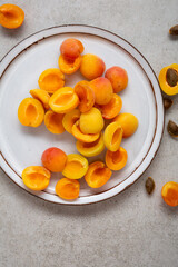 Top view of fresh apricot halves on a plate summer fruits concept