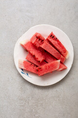 Top view of sliced watermelon on plate summer food on grey surface