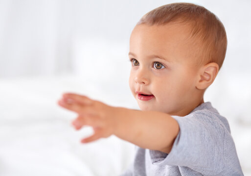 Fascinated by his surroundings. Image of a little baby boy reaching out his hand.