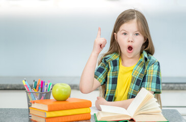 Surprised young girl reads the book and has idea. Success, idea and creative concept