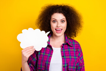 Photo of pretty excited woman dressed plaid shirt holding speaking bubble empty space isolated yellow color background