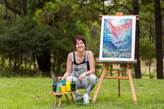 Portrait of teen girl squatting beside art project outdoors