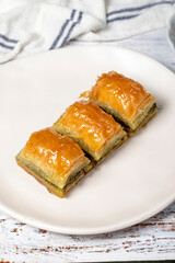 Turkish baklava. Pistachio baklava on wooden background. Traditional Mediterranean cuisine delicacies. Close up
