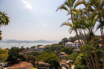 Fototapeta na wymiar Aerial view of Gulangyu island with Palm trees at the foreground. Blue sky with copy space for text