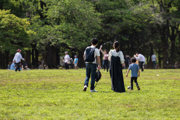 公園を散歩する若い家族
