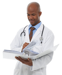 Familiarizing himself with the patients history. A young african doctor paging through a patients medical records.