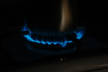 Close up burning gas on stove surface ring, blue natural flames, domestic kitchen propane butane oven. Gas global enerhycrisis, high price rise, sanctions

