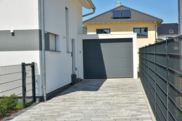 Moderne Beton-Garage mit Automatik-Tor in der Hauszufahrt