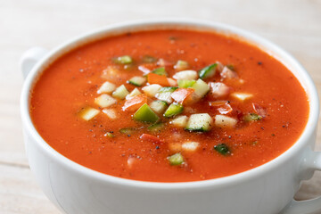 Traditional Spanish gazpacho soup in bowl on wooden table. Close up