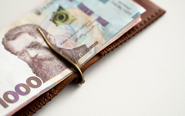 Ukrainian hryvnia money in leather money clip, wallet. Ukraine money on white background with. Currency of Ukraine. Accessories. Money, financess, economy, saving.