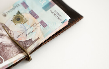 Ukrainian hryvnia money in leather money clip, wallet. Ukraine money on white background with. Currency of Ukraine. Accessories. Money, financess, economy, saving.