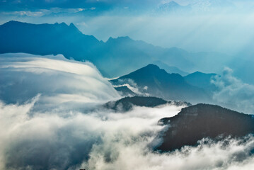 Fototapeta na wymiar High mountains covered by clouds, sea of clouds, mountain tops, thick clouds