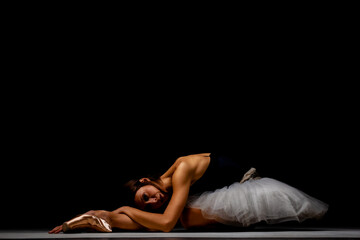 ballerina with a tutu posing on the floor - obrazy, fototapety, plakaty