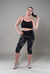 Plus size young woman in fitness clothing