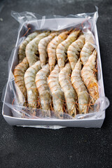 Naklejka premium gambas raw frozen in ice big shrimp seafood prawn meal food snack pescatarian diet on the table copy space food background rustic top view keto or paleo
