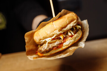 Man Black Gloves Holding Burger Hands Juicy Burger Close Appetizing burger.