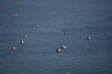 Full frame shot of fishing boats in the Arabian sea at Goa in India. Boats as seen from the top of the hill in Goa. Fishing boats in the sea. Boats fishing in the Arabian sea. - obrazy, fototapety, plakaty
