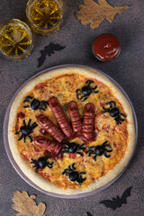 Halloween pizza with sausage fingers and spiders on brown background, Creative idea for Halloween
