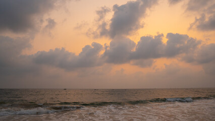 Wide angle shot of Baga beach during the sunset with clouds above the ocean at North Goa in Goa, India. Clouds above the sea waves with dramatic sky after the sunset. Beach Background