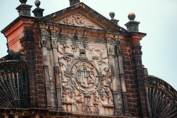 Closeup shot of writings on the top of the Basilica of Bom Jesus monument in Goa, India. Ancient...