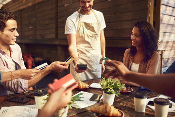 Let the waiter decide wholl be paying. a group of colleagues holding out their bank cards to pay...