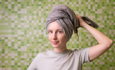 A woman with a towel on her head, taking care of herself, her hair.