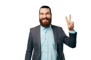 Handsome bearded man wearing jacket is showing the victory or peace gesture over white background.