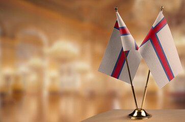 Small flags of the Faroe Islands on an abstract blurry background